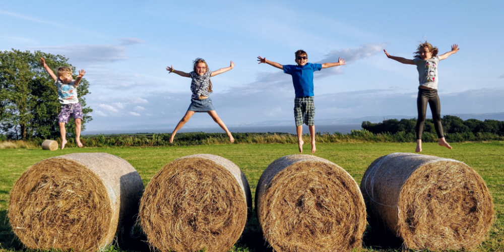 Enfants sur une tournée de balles de foin de BelFarm